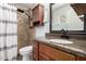 Bathroom featuring a granite countertop and shower with tan tile at 3503 E Campo Bello Dr, Phoenix, AZ 85032