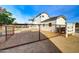 View of backyard with metal fencing and two-story home featuring a balcony at 3929 E Flintlock Dr, Queen Creek, AZ 85142