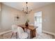 Cozy dining room with modern chandelier, wood table, and access to another room at 3929 E Flintlock Dr, Queen Creek, AZ 85142