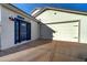 Attached white garage, blue entry door, and concrete driveway on a sunny day at 3929 E Flintlock Dr, Queen Creek, AZ 85142