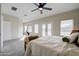 This large main bedroom has carpet, a sitting nook, a ceiling fan, and an ensuite bathroom at 3929 E Flintlock Dr, Queen Creek, AZ 85142