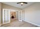 Neutral-toned room with glass paneled double doors leading to a dining area with ceiling fan at 3929 E Flintlock Dr, Queen Creek, AZ 85142