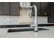 Close up of a modern kitchen faucet, with bright quartz countertop and decorative backsplash at 3951 E Gold Mountain Ave, San Tan Valley, AZ 85143