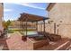 Landscaped backyard featuring a pergola with raised garden beds and a gravel ground cover at 4019 W Valley View Dr, Laveen, AZ 85339