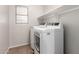 Modern laundry room with machines, tile floors and white shelves at 4019 W Valley View Dr, Laveen, AZ 85339