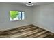 Bedroom featuring wood-look flooring, and a window, creating a comfortable and stylish living space at 4065 E University Dr # 407, Mesa, AZ 85205