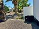 Exterior view showcasing desert landscaping with rocks, palm trees, and an air conditioning unit at 4065 E University Dr # 407, Mesa, AZ 85205