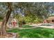 Scenic backyard with a pool, playhouse, mature trees, lush landscaping, and a charming walkway at 4222 E Brown Rd # 18, Mesa, AZ 85205