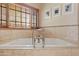 Luxurious bathroom with a soaking tub and travertine tile at 4222 E Brown Rd # 18, Mesa, AZ 85205