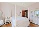 Charming bedroom with a white four-poster bed, chandelier, and light pink walls at 4222 E Brown Rd # 18, Mesa, AZ 85205