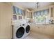 Bright laundry room featuring modern washer and dryer, custom cabinets, and a farmhouse sink at 4222 E Brown Rd # 18, Mesa, AZ 85205