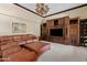 Spacious living room featuring custom built-ins, large leather sectional, and neutral carpeting at 4222 E Brown Rd # 18, Mesa, AZ 85205