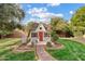 Charming playhouse with a decorative heart, red door, and a brick path nestled in a lush green yard at 4222 E Brown Rd # 18, Mesa, AZ 85205