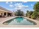 Backyard pool with an expansive patio deck, mature trees, and lush landscaping with grass at 4222 E Brown Rd # 18, Mesa, AZ 85205