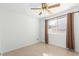 Well-lit bedroom features a ceiling fan and a window with curtains at 4323 W Villa Theresa Dr, Glendale, AZ 85308