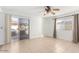 Sunlit bedroom with sliding glass doors to backyard, tile flooring, ceiling fan, and neutral walls at 4323 W Villa Theresa Dr, Glendale, AZ 85308