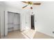 Bright bedroom with ceiling fan and a closet with shelving at 4323 W Villa Theresa Dr, Glendale, AZ 85308