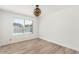 Bright bedroom with laminate floors, a modern light fixture, and a large window overlooking the pool at 4323 W Villa Theresa Dr, Glendale, AZ 85308