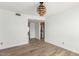 Spacious living room with laminate floors, a modern light fixture, and an open layout to the kitchen at 4323 W Villa Theresa Dr, Glendale, AZ 85308