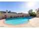 Backyard pool featuring clear blue water, privacy wall lined with decorative pots, and ample space for lounging poolside at 4323 W Villa Theresa Dr, Glendale, AZ 85308