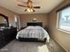 Bedroom featuring a dark wood dresser, carpet, ceiling fan, and large window at 4530 E Dragoon Ave, Mesa, AZ 85206