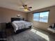 Bright bedroom with large window showing the neighborhood, carpet, and ceiling fan at 4530 E Dragoon Ave, Mesa, AZ 85206