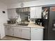 Well-lit kitchen featuring stainless steel refrigerator, white cabinets, tile floor and modern appliances at 4530 E Dragoon Ave, Mesa, AZ 85206