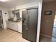 Well-lit kitchen featuring stainless steel refrigerator, white cabinets, tile floor and modern appliances at 4530 E Dragoon Ave, Mesa, AZ 85206