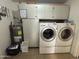 Laundry room featuring washer, dryer, water heater, storage cabinets, and tile floors at 4530 E Dragoon Ave, Mesa, AZ 85206