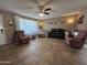 Comfortable living room featuring tile flooring, a ceiling fan, neutral-colored walls, and large front windows at 4530 E Dragoon Ave, Mesa, AZ 85206