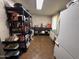 Spacious storage room featuring vinyl floors, a refrigerator, shelving, and a utility table at 4530 E Dragoon Ave, Mesa, AZ 85206