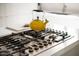 Close-up of modern stainless steel gas cooktop and yellow teapot at 4530 N 9Th Ave, Phoenix, AZ 85013