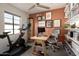 Bright home office featuring an exercise bike, desk, floating shelves, and neutral color palette at 4530 N 9Th Ave, Phoenix, AZ 85013