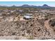 Desert home aerial showing the dwelling's setting among rolling hills and city views at 50408 N 22Nd Ave, New River, AZ 85087