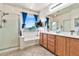 Bathroom with a soaking tub, shower, double vanity, and a window with a picturesque view at 5110 S Sandstone St, Gilbert, AZ 85298