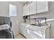 The laundry room features plenty of cabinet space and a modern washer and dryer at 5110 S Sandstone St, Gilbert, AZ 85298