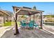 Outdoor patio under gazebo has a dining table with six chairs and a clear view of the private swimming pool and fenced yard at 5110 S Sandstone St, Gilbert, AZ 85298