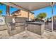 Outdoor kitchen has stainless steel grill, concrete countertops, stucco base and view into backyard fountain and seating area at 5110 S Sandstone St, Gilbert, AZ 85298