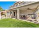 An inviting covered patio with ceiling fans, plush seating, and artificial grass beyond the fence at 5110 S Sandstone St, Gilbert, AZ 85298