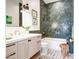 Elegant bathroom showcasing green herringbone tile, a soaking tub, and chic black-and-gold fixtures at 5144 E Calle Del Medio --, Phoenix, AZ 85018