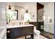 Modern bathroom featuring a dark vanity, a shower with black-and-white tiling, and stylish fixtures at 5144 E Calle Del Medio --, Phoenix, AZ 85018