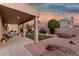 Inviting backyard with covered patio, lush green grass, gravel landscaping, and mature shade trees at 5545 E Helena Dr, Scottsdale, AZ 85254