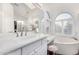 Bright bathroom featuring double sinks, lots of counter space, and a soaking tub under a large window at 5545 E Helena Dr, Scottsdale, AZ 85254