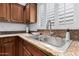 Close up on the kitchen sink with granite countertops and white shuttered windows at 5545 E Helena Dr, Scottsdale, AZ 85254