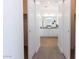 Hallway view of a modern bathroom with double sinks, white cabinets, and wood flooring at 5708 S Daisy Patch Pl, Phoenix, AZ 85040