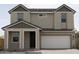 Traditional home exterior boasts neutral stucco, and two-car garage with gray stone accents at 5708 S Daisy Patch Pl, Phoenix, AZ 85040