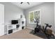 Bedroom includes a Peloton exercise bike, TV, and a window with shutters, creating a convenient fitness space at 5904 E Calle De Las Estrellas Rd, Cave Creek, AZ 85331