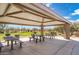 Outdoor picnic area featuring several tables and grills beneath a shaded pavilion surrounded by a green landscape at 5904 E Calle De Las Estrellas Rd, Cave Creek, AZ 85331