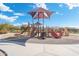 A vibrant and engaging playground featuring slides and climbing structures, set on a sand base and bordered by a paved path at 5904 E Calle De Las Estrellas Rd, Cave Creek, AZ 85331