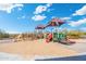 A colorful and fun playground with slides, climbing structures, and sunshades, set on a sand base with a paved border at 5904 E Calle De Las Estrellas Rd, Cave Creek, AZ 85331